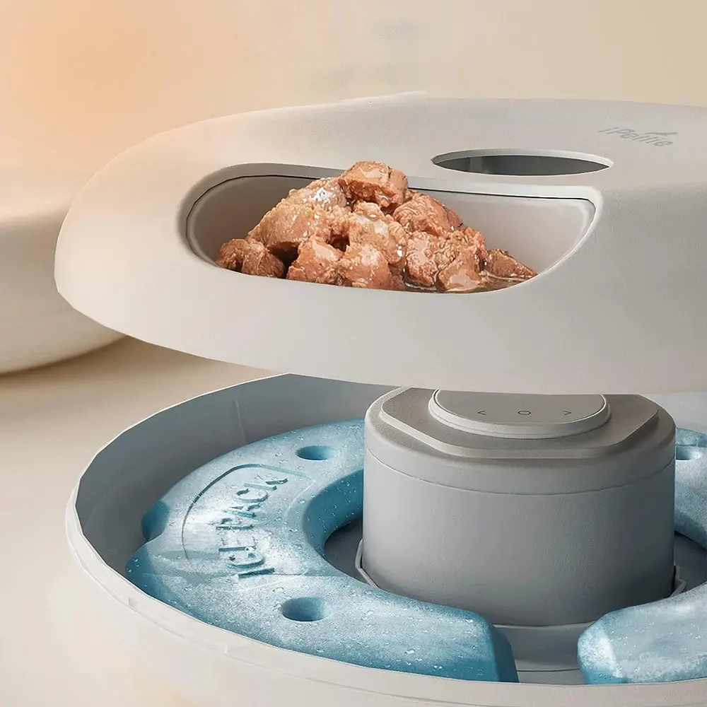 Vue éclatée du distributeur montrant le compartiment repas ouvert et le pain de glace bleu en dessous