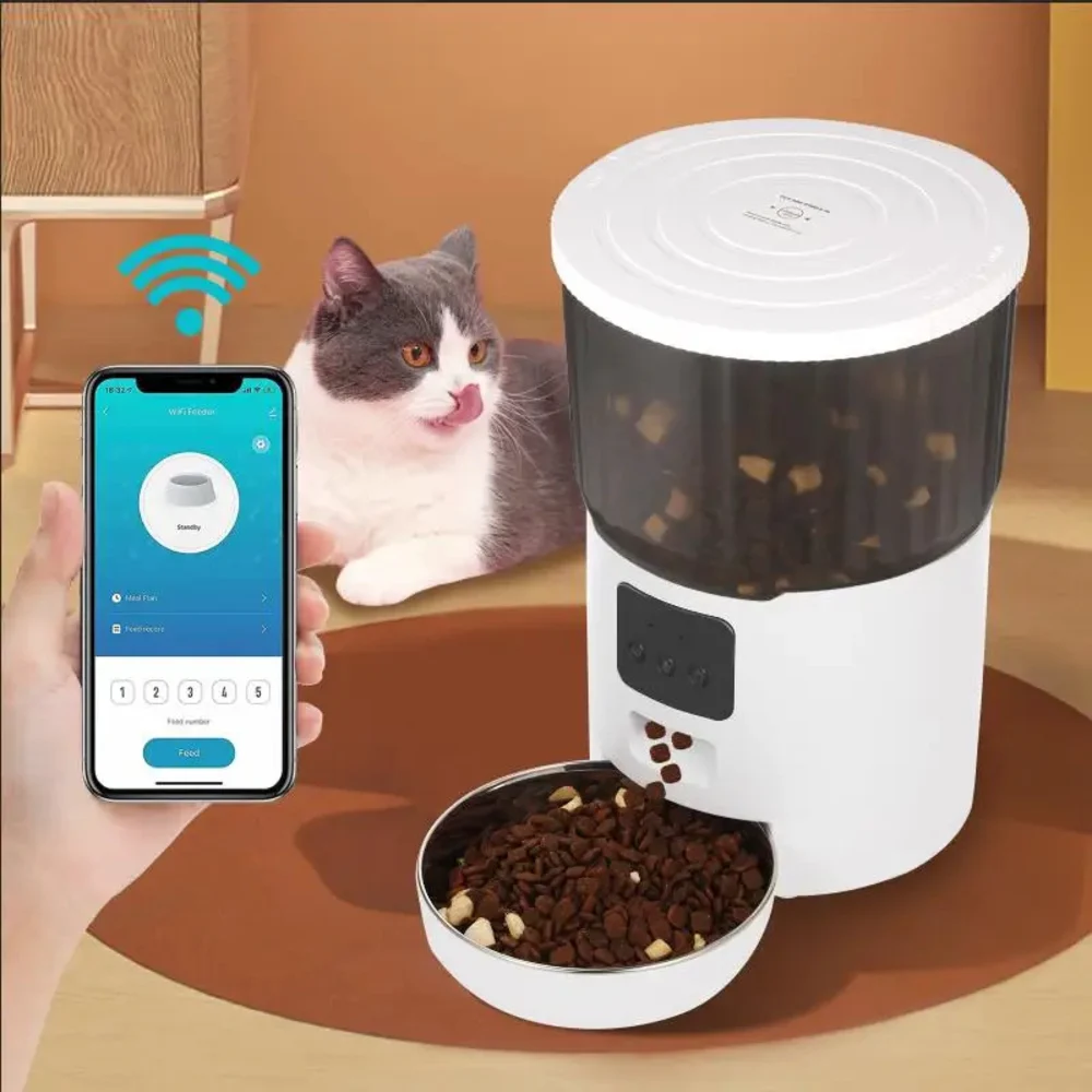 Main tenant un smartphone avec l'app Wi-Fi Feeder, nourrisseur blanc et chat en arrière-plan
