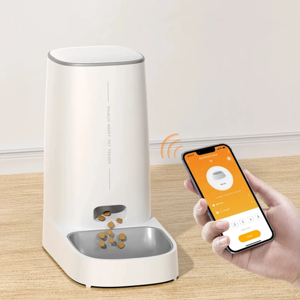Distributeur croquette connecté blanc avec smartphone affichant l'application ROJECO en orange