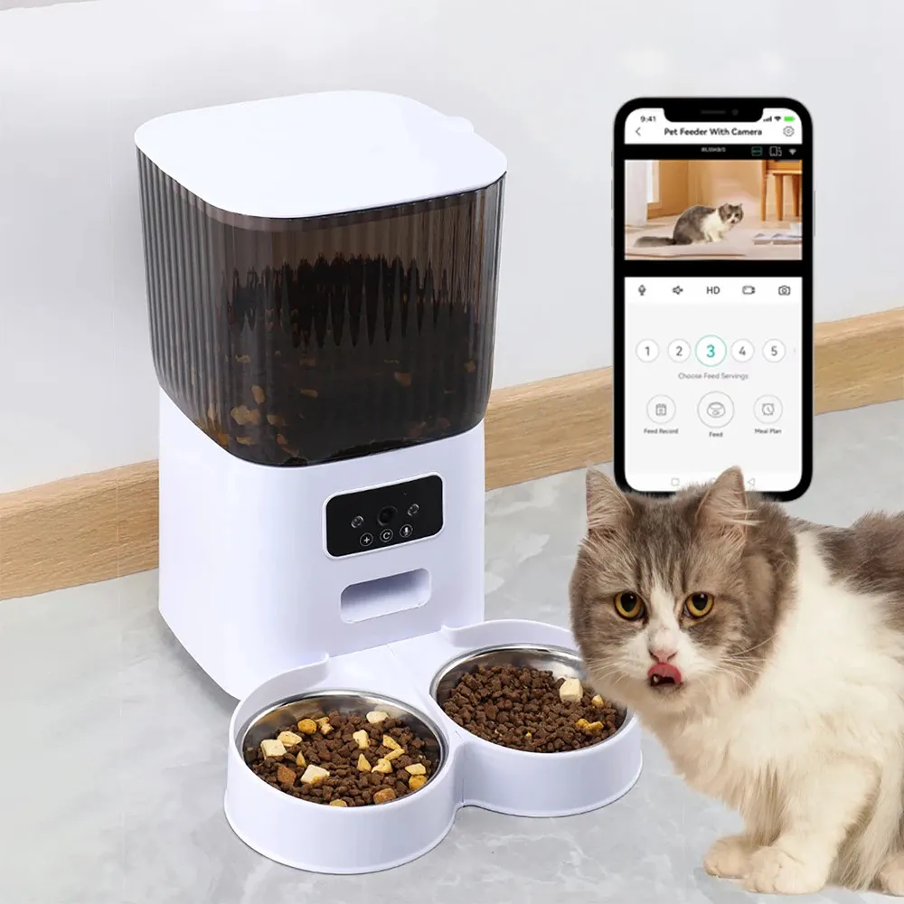 Distributeur automatique connecté blanc avec deux gamelles inox et chat gris à côté