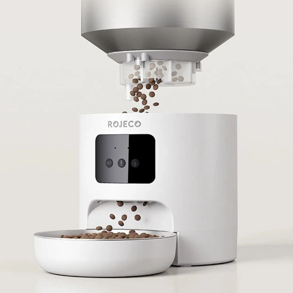 Mécanisme rotor distributeur Rojeco versant croquettes dans gamelle blanche gros plan