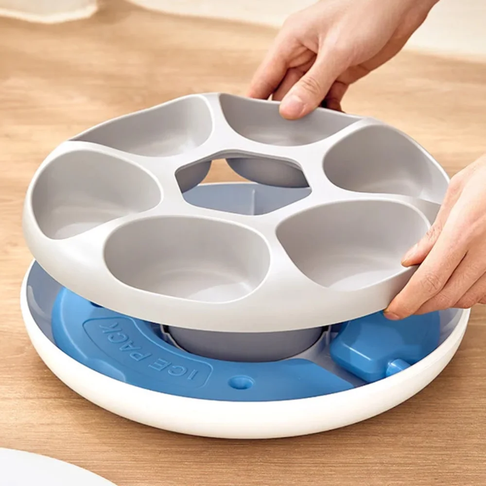 Mains retirant le plateau amovible à six compartiments du nourrisseur automatique Rojeco, pains de glace visibles