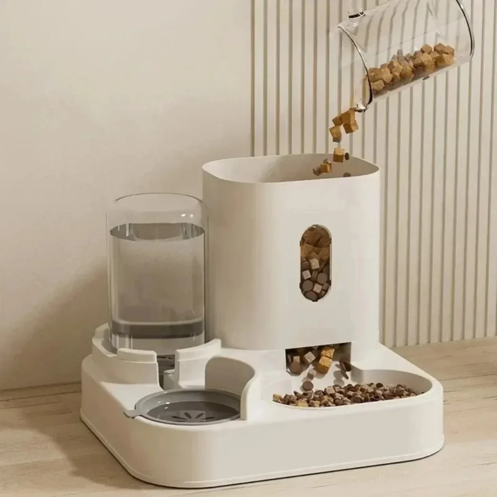 Chargement des croquettes dans le distributeur pour chat depuis un récipient transparent