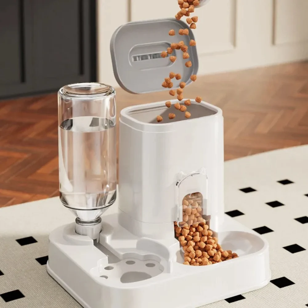 Distributeur croquette chat blanc ouvert avec croquettes versées dedans et bouteille eau transparente