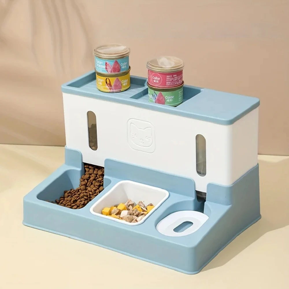 Nourrisseur automatique bleu et blanc avec boîtes de pâtée posées sur le dessus, gamelles remplies