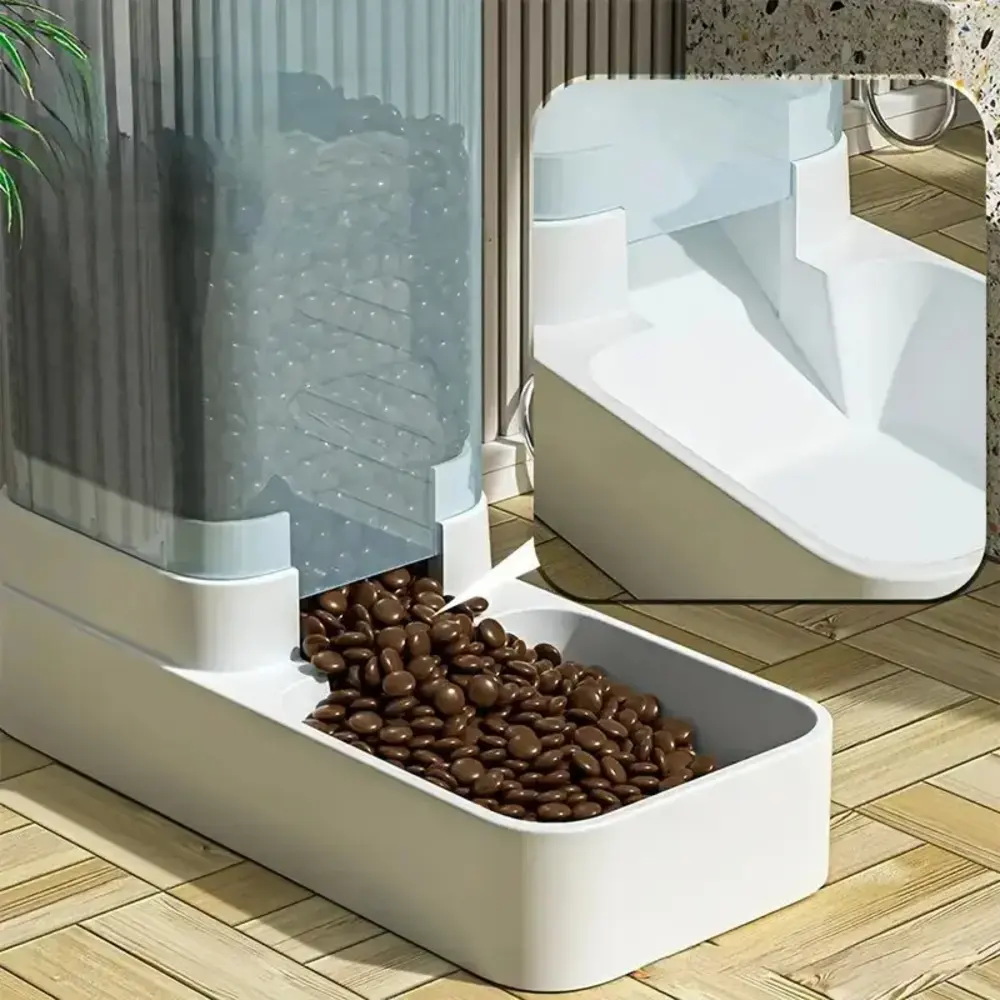 Gros plan sur le bas du distributeur croquette avec kibbles bruns qui tombent dans la gamelle blanche